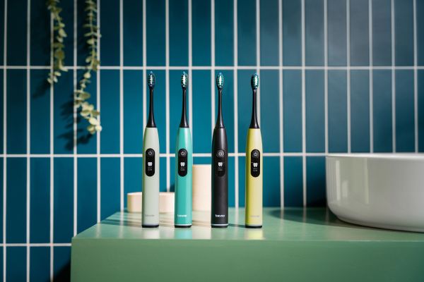 The image shows the SC 50 Sonic Toothbrush in a bathroom in the colours Peppermint, Ocean Breeze, Midnight Ink and Splashy Lemon.