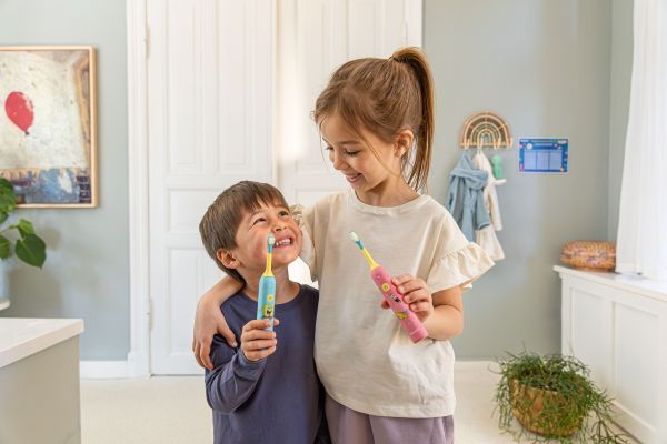 Ein Junge und ein Mädchen mit der neuen Kinder-Schallzahnbürste SC 11.