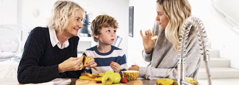 La famiglia mangia frutta insieme in cucina