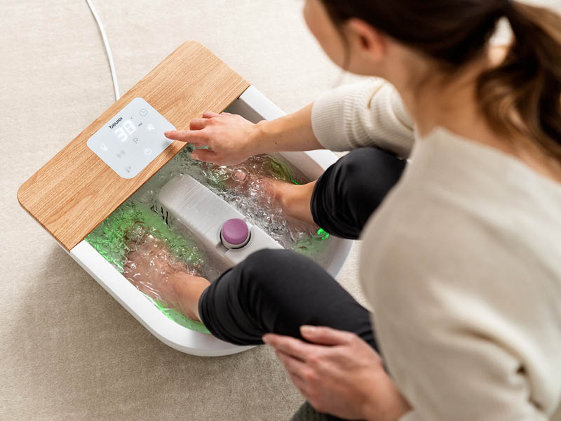Mujer disfruta de un relajante baño para pies con el hidromasaje para pies Wellness FB 65 de Beurer