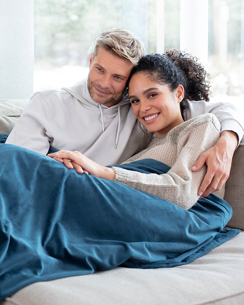 Beurer Couverture chauffante HD 75 cosy ocean - Image d'application Couple allongé sur le canapé sous la couverture chauffante